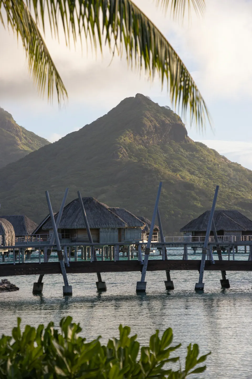 Overwater bungalows, palm trees, and a mountain beside the Bora Bora lagoon